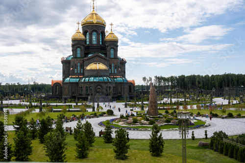 panoramic view of a dark temple with golden domes against a background of gray clouds