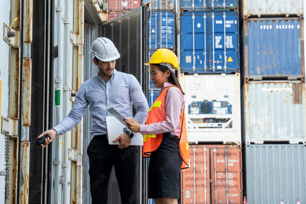 Businessman and businesswoman working together at container cargo,Warehouse shipping transportation concept for logistic. Businessman and businesswoman working together at container cargo,Warehouse shipping transportation concept for logistic.
