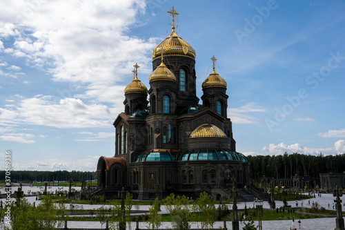 panoramic view of a dark temple with golden domes against a background of gray clouds