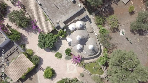 Aerial top down view of Trullo in Puglia Italy. Traditional italian white stone houses in olive grove. Ceglie Messapica, South Italy. Summer sunny day. Natural landscape.