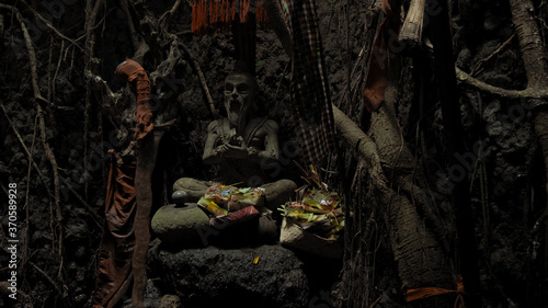 Religious place for rites with ancient statues of people in a dark cave with strong shadows