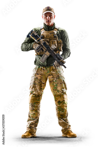 Army soldier in Protective Combat Uniform holding Special Operations Forces Combat Assault Rifle isolated on white background