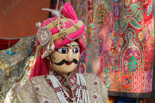 Indian traditional doll in a pink turban. Mustache character in traditional Indian clothing. photo