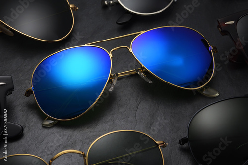 Different sunglasses on black slate background