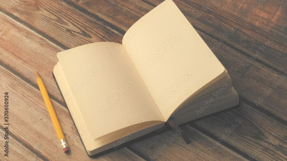 open book and a pencil on wooden table 