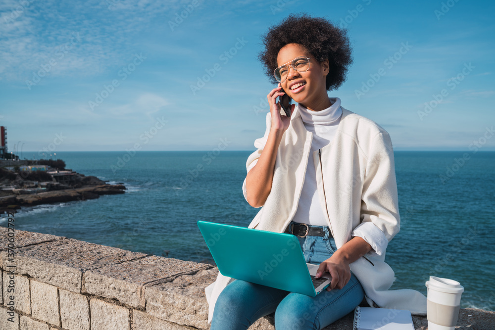 Woman using her laptop and talking on phone. Woman using her laptop and talking on phone.