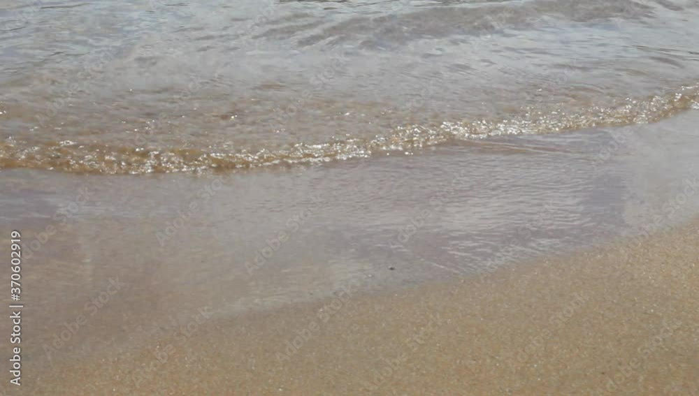 Crystal-clear water waves arriving at the beach with soft sand Crystal-clear water waves arriving at the beach with soft sand