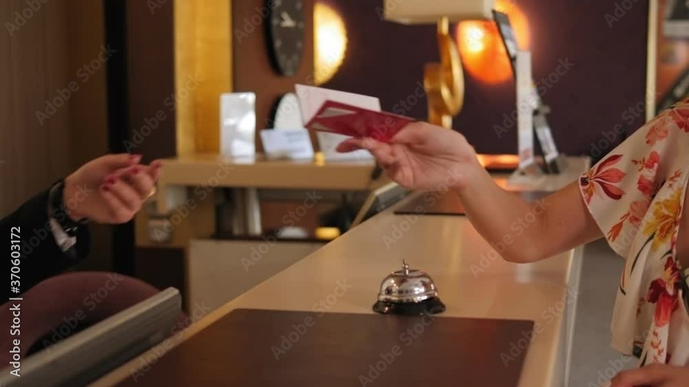 Close-up of the hotel receptionist gives the girl an electronic key to the room at the reception. Slow motion.