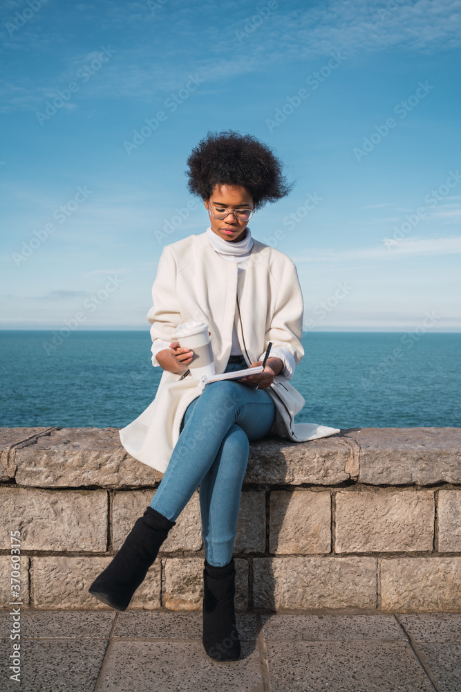 Latin woman writing something outdoors. Latin woman writing something outdoors.