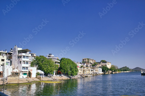 Indian Houses next to a lake located in Udaipur city in Rajasthan state, India © Arpan