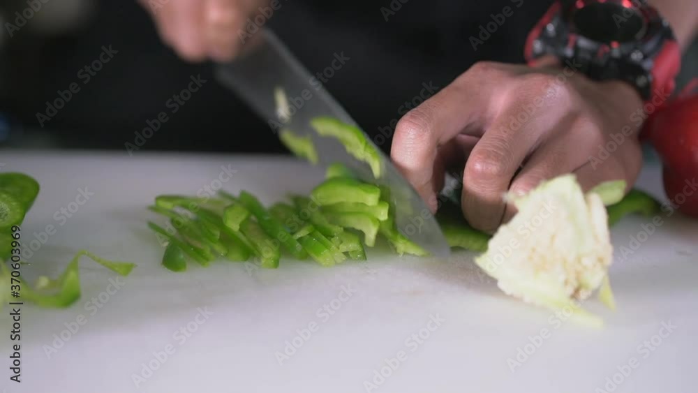 Cutting green pepper in the kitchen with knife Cutting green pepper in the kitchen with knife