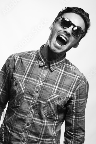 emotional studio portrait of a male brunette wearing sunglasses black and white image