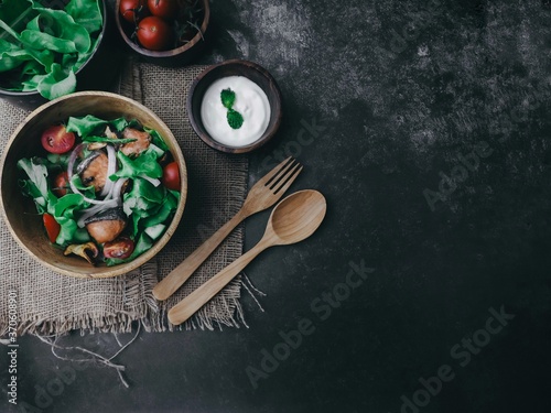 Food background and copy space, view,Roasted salmon fillet with fresh vegetable salad on wooden bowl , grilled salmon and tomatoes, cucumbers, olives and red onion,clean and healthy food concept.