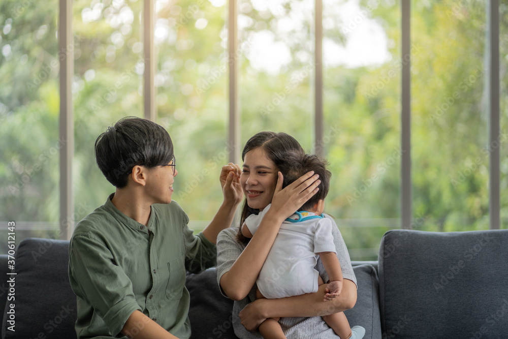 Fototapeta premium Diversity Lesbian sitting with cute toddler girl in between. Happiness and family bonding in LGBTQ family, LGBT lifestyle.