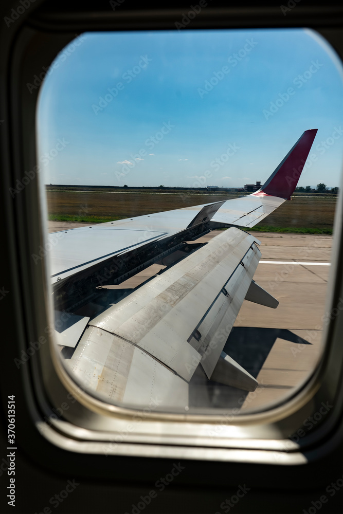 View from the airplane window on the wing with the flaps extended.