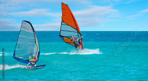 Beautiful cloudy sky with windsurfer surfing the wind on waves in Alacati - Cesme, Turkey 