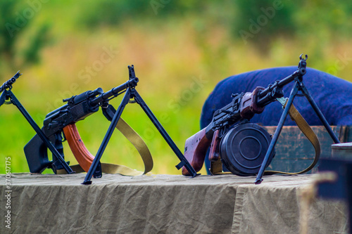 Degtyarev RPD hand machine gun and Kalashnikov RPK Hand machine gun, mounted on a table covered with a raincoat, image for magazines and articles about military equipment. photo