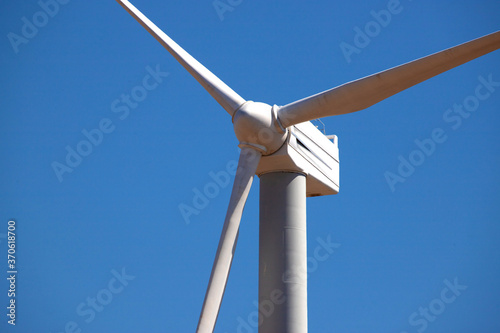                            Wind Generator Turbine in Bright Sun Light on the Clear Blue Sky Background. High quality photo
