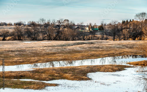 Obraz na płótnie Flooded trees and frozen water in the floodplain of the river at the thaws. w salonie
