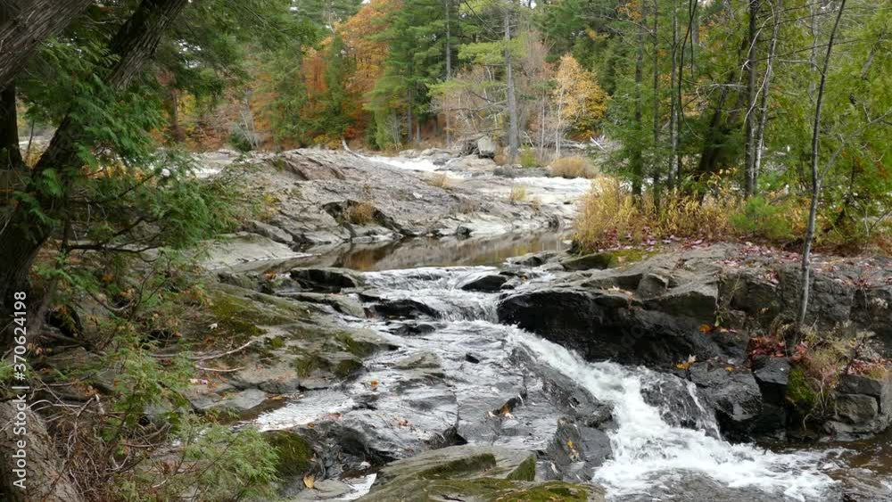 Beautiful natural setting of a river in autumn running down through vegetation Beautiful natural setting of a river in autumn running down through vegetation