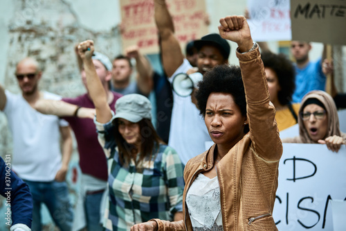 Black woman with raised fist on anti-racism protest. photo