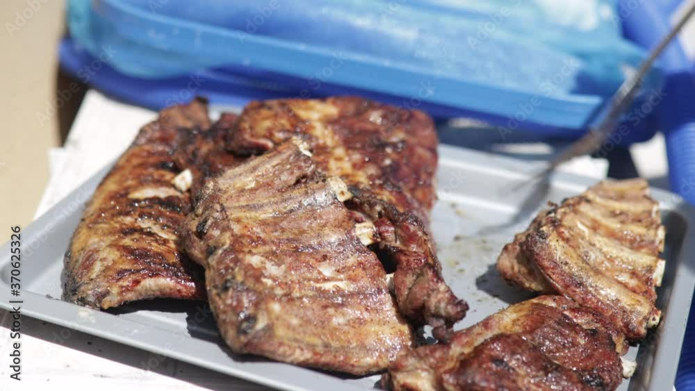 Close up shot of pork ribs cooked on the grill. Leisure concept with friends Close up shot of pork ribs cooked on the grill. Leisure concept with friends