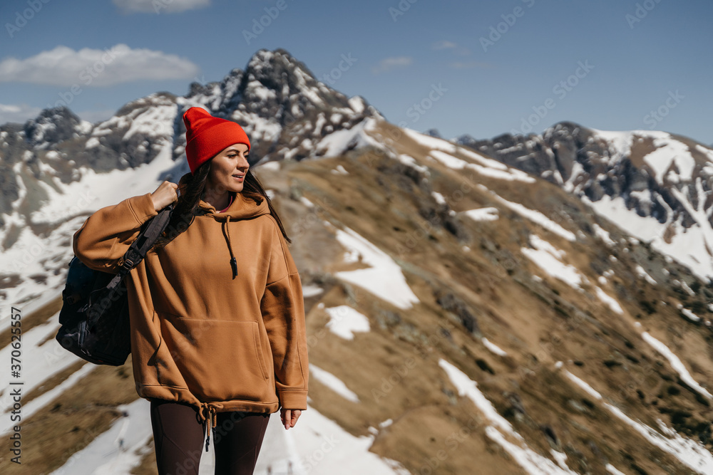 Naklejka premium young girl in the mountains with a backpack. Active rest in one with nature