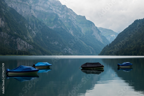 The lake Kloental with boats in Switzerland, Glarus on a cloudy day day, copyspace between mountains, moody picture, hotspot for influencers. © brunok1