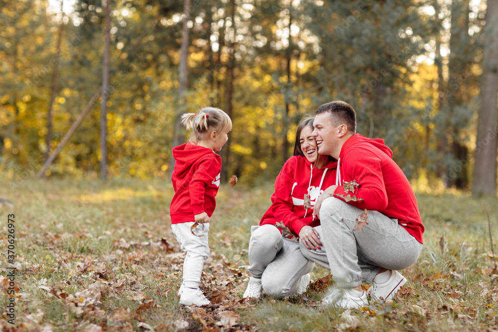Fototapeta premium dad, mom and little cute daughter having fun and playing in the autumn park. family concept, father's, mother's and baby's day