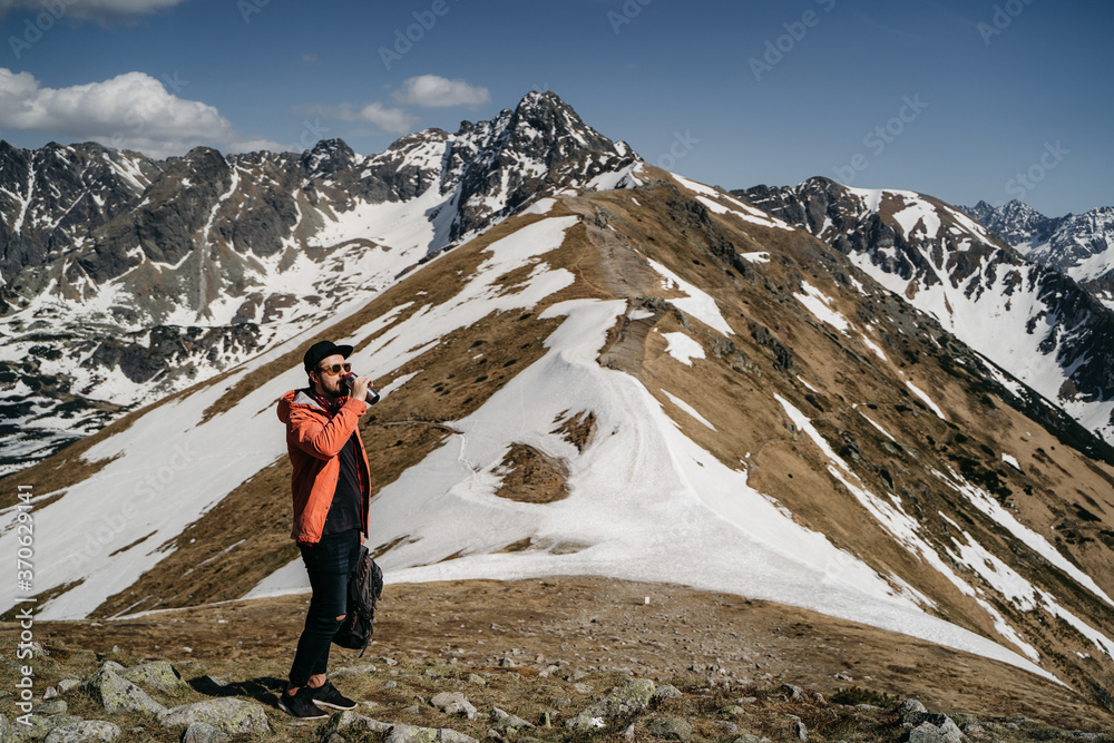Guy drinking water in the mountains .Hiker drinking water Guy drinking water in the mountains .Hiker drinking water