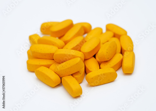 Big orange pills on a white background. Oval tablets of calcium and magnesium. Dietary supplements in capsule form.