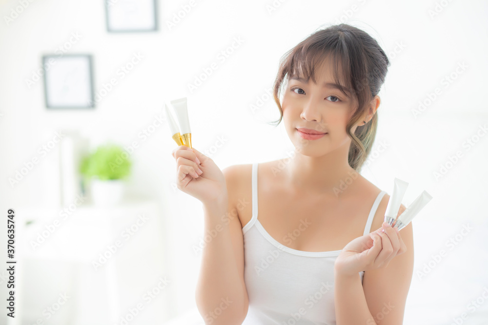 Beautiful portrait young asian woman holding and presenting cream or lotion product, beauty asia girl show cosmetic makeup and moisturizing for skin care, healthy care and wellness concept. Beautiful portrait young asian woman holding and presenting cream or lotion product, beauty asia girl show cosmetic makeup and moisturizing for skin care, healthy care and wellness concept.