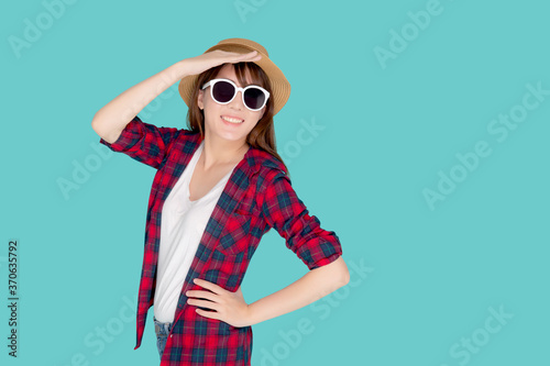Beautiful portrait young asian woman wear sunglasses and hat smile excited and confident enjoy summer trip holiday isolated blue background  girl cheerful having backpack in vacation  travel concept.