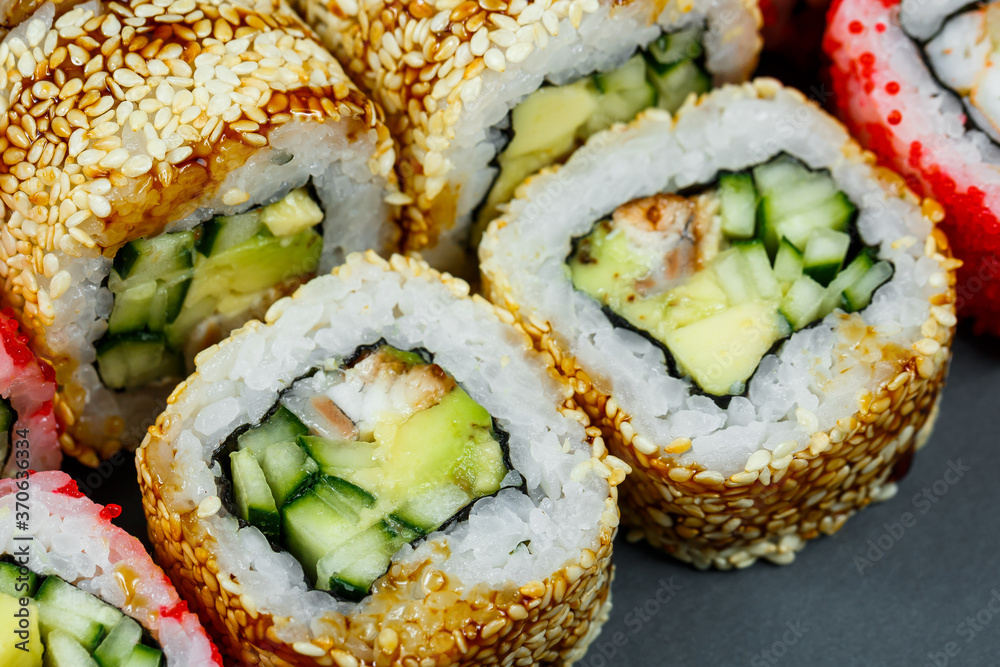 Sushi assorted. Sushi roll with avocado, cucumber. Sushi roll with salmon and caviar. Sushi roll with tuna and caviar. On a light background. Japanese food. View from above Sushi assorted. Sushi roll with avocado, cucumber. Sushi roll with salmon and caviar. Sushi roll with tuna and caviar. On a light background. Japanese food. View from above