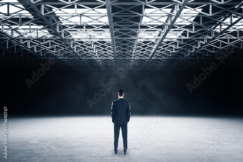Businessman standing in showroom with metal structure on ceiling. © Who is Danny