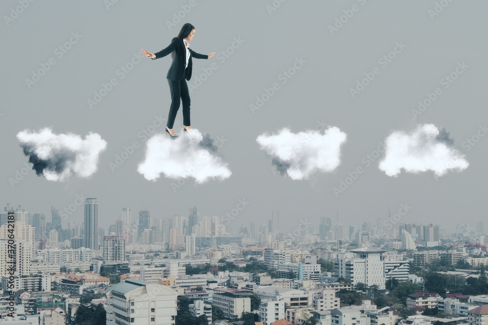 Businesswoman in suit walking on clouds Businesswoman in suit walking on clouds