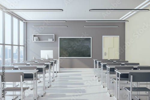 Light classroom interior with empty chalkboard photo
