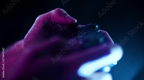 Playing video games in a darkened room with a black background close up on a controller joystick playing quickly blue lens flare photo