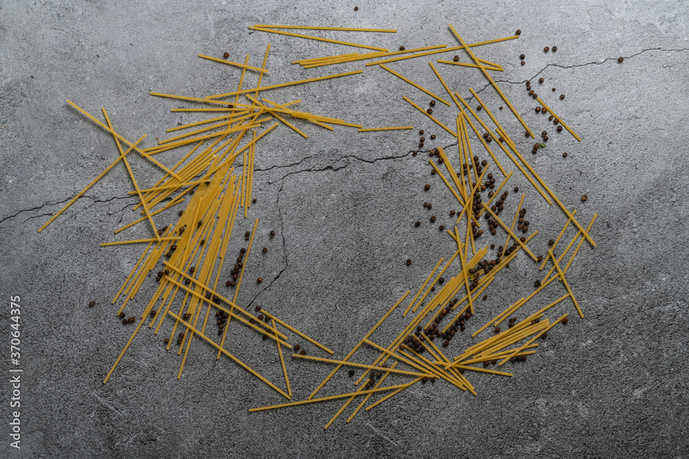 Yellow pasta on a gray background. Spaghetti on cement background. Raw spaghetti bolognese. Food background concept. Top view
