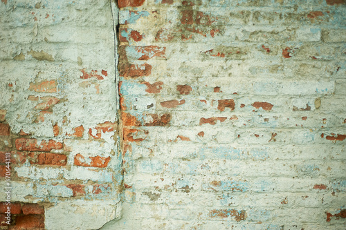 Wall with painted brick and peeled paint.Texture. Abandonment.