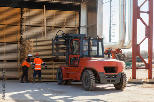 workers load boards with an industrial loader at a sawmill photo