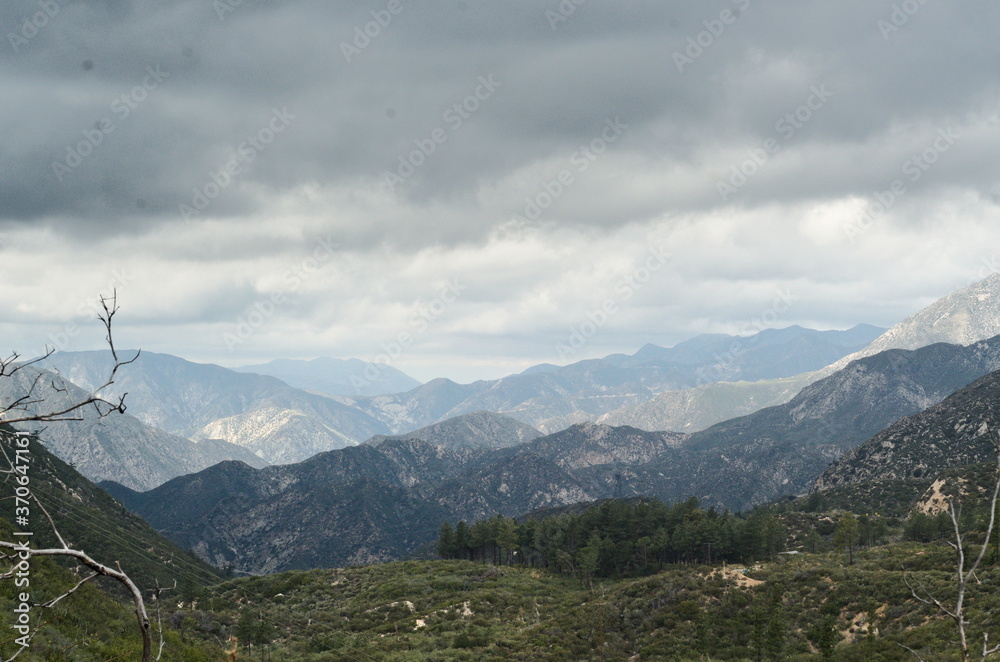 Vast panoramic vista of Angeles forest and mountains of landscape, beautifully detailed and threatening clouds help to add drama and prospective, hard to be;lieve LA is close-b, inspiring and tranquil