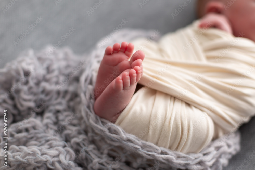 legs of a newborn baby in a white blanket. newborn