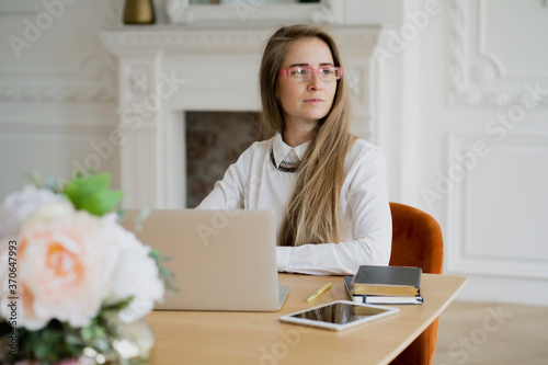 a woman is working on a laptop computer with pink glasses