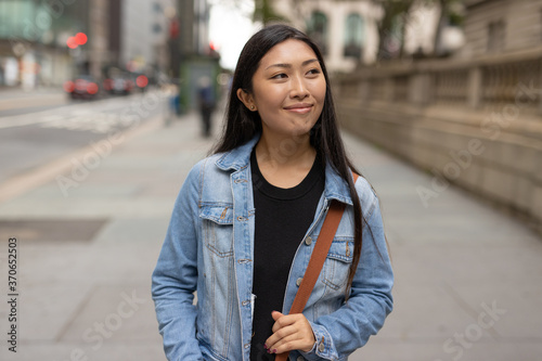 Young Asian woman walking city street smiling happy © blvdone