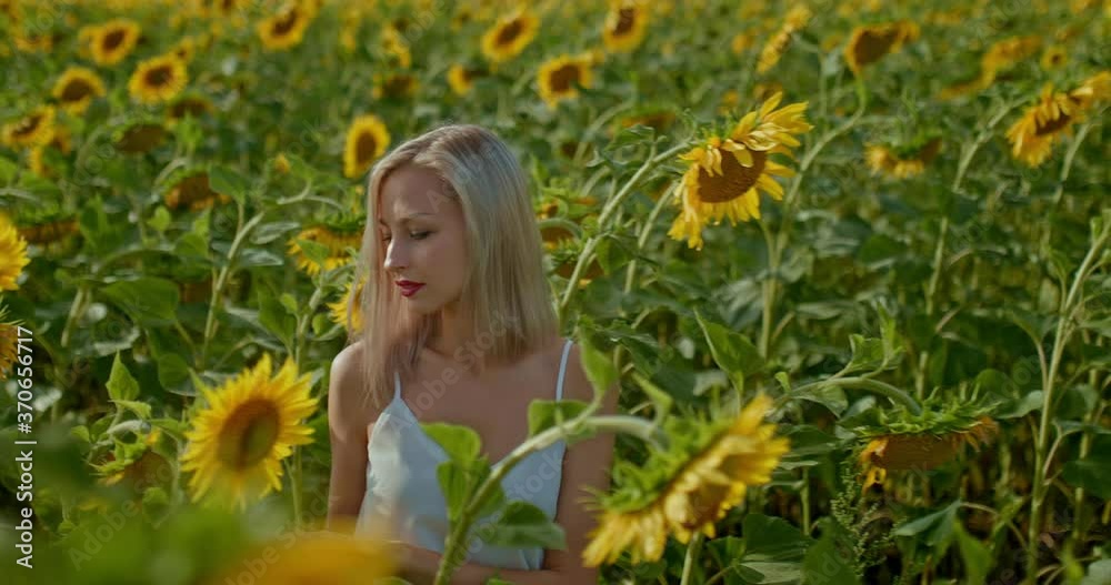 Beautiful young woman is walking on an endless field with sunflowers, she is happy. Woman is enjoying a walk in the field. Portrait view. 4k, 10bit, ProRes Beautiful young woman is walking on an endless field with sunflowers, she is happy. Woman is enjoying a walk in the field. Portrait view. 4k, 10bit, ProRes