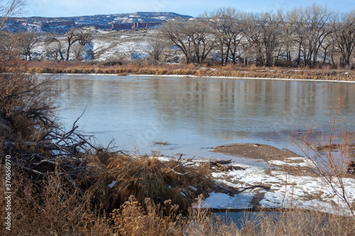 Colorado River in winter with snowy canyons in the background.