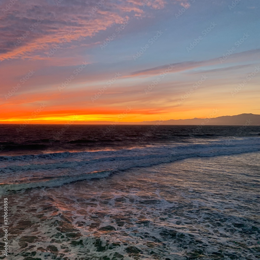 Obraz premium Vibrant tricolor sunset over coastal island seascape