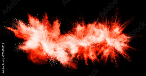 Red powder explosion on black background. Paint Holi.