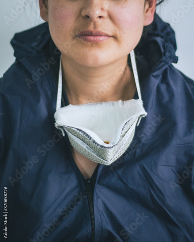 Doctora con traje protector y mascarilla protectora luego de una jornada de trabajo durante la pandemia por el COVID. Mujer con equipo preventivo  contra el Covid 19 al finalizar un dia de trabajo.